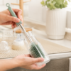 Silicone bottle brush cleaning a glass baby bottle