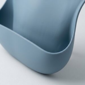 Close-up of the open food-catching pocket and supported sidewalls on a silicone baby bib