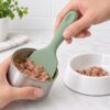 Silicone pet food spatula scraping wet cat food from a metal can